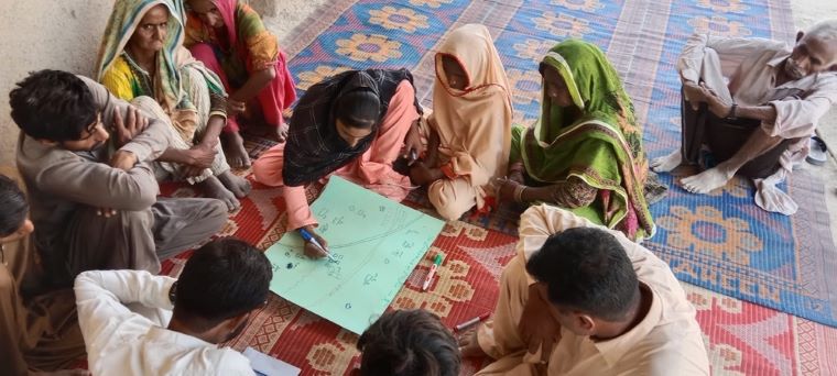 ダードゥでコミュニティの状況を地図に書き込みながら話し合うスタッフら=10月31日 © MSF