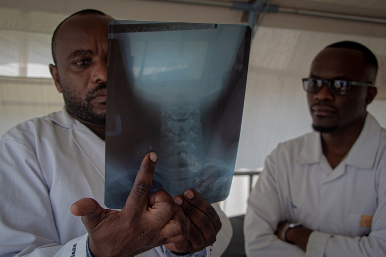 体の中に銃弾が残っていることを示すレントゲン写真を見る医療スタッフ　© Marion Molinari/MSF