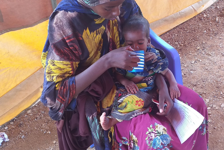 MSFの施設を訪れた母親が、栄養補助食品のミルクを子どもに飲ませる　Ⓒ MSF/Suleiman Hassan