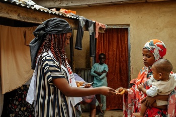 飲み水を塩素消毒するための錠剤を手渡す<br> MSFのヘルスプロモーター © MSF/Hussein Amri