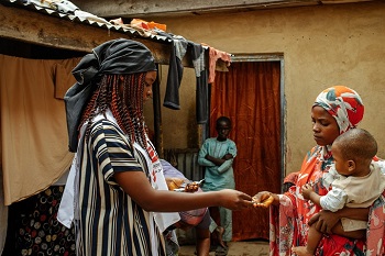 飲み水を塩素消毒するための錠剤を手渡す<br> MSFのヘルスプロモーター　© MSF/Hussein Amri