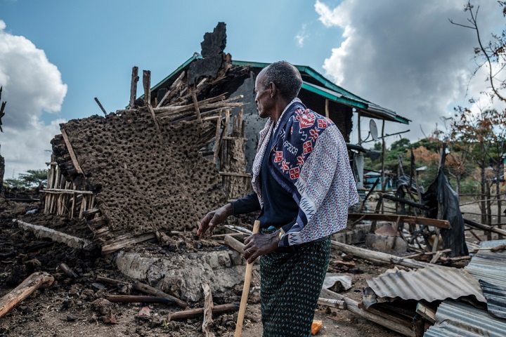 戦闘によって破壊された自宅を見つめる村人　© Eduardo Soteras Jalil
