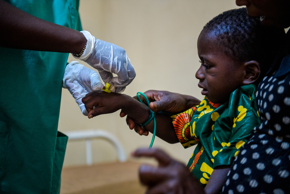 ジフテリアの治療を受ける子ども。医師から点滴を受けている　© MSF/Andrej Ivanov