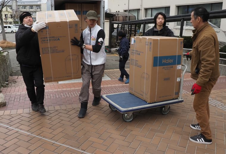 洗濯機を運び込む市とMSFのスタッフら © MSF