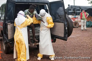 MSFスタッフに支えられて救急搬送車から降りる感染疑いの女性