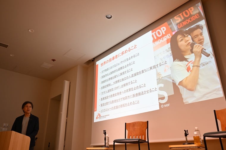 スクリーンに映し出された、MSFが世界の指導者に求める八つの行動を読み上げるMSF日本広報部ディレクターの舘俊平(左)=東京都で2025年10月3日 Ⓒ MSF
