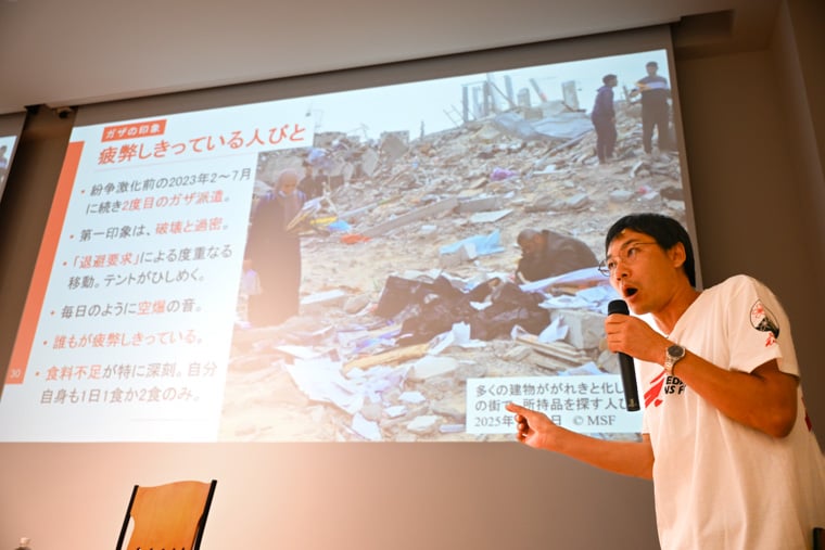 多くの建物ががれきと化した現在のガザ地区の写真を映しながら、紛争激化前との違いについて語る松田=東京都で2025年10月3日 Ⓒ MSF