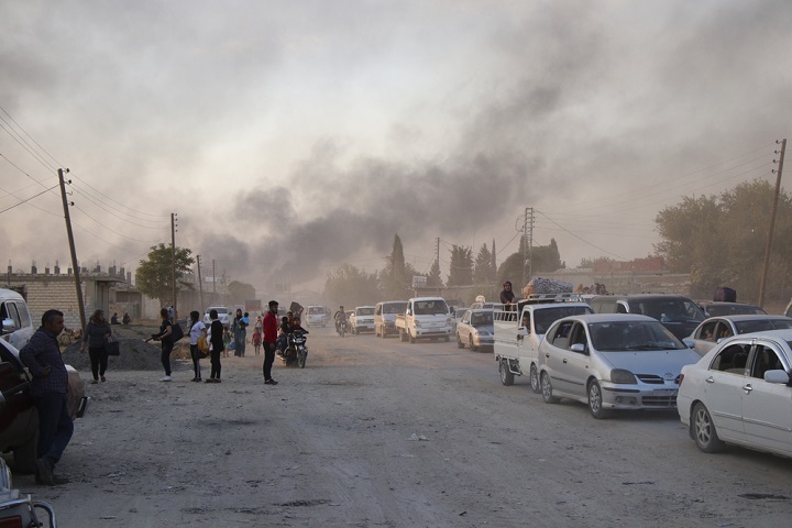 トルコ軍による砲撃から逃げる人びと（シリア北東部ラス・アル・アインで10月9日撮影）© AP Photo