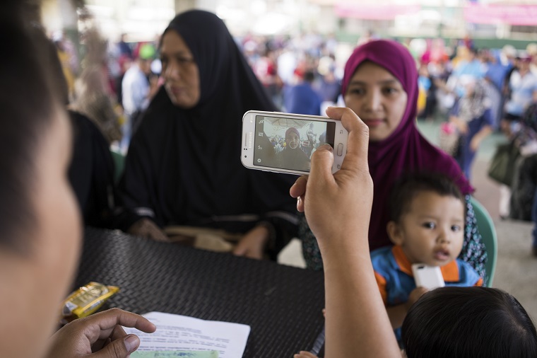フィリピンのマラウィ市で生活支援をするため、スマホのアプリで避難者を登録するICRCスタッフ ©ICRC