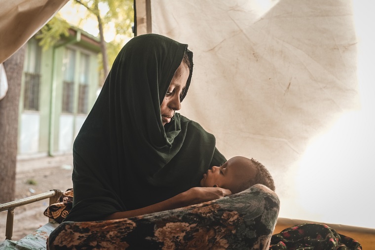 入院栄養治療センターで息子が寝ているのを見守る母親=2022年6月1日 © Njiiri Karago/MSF