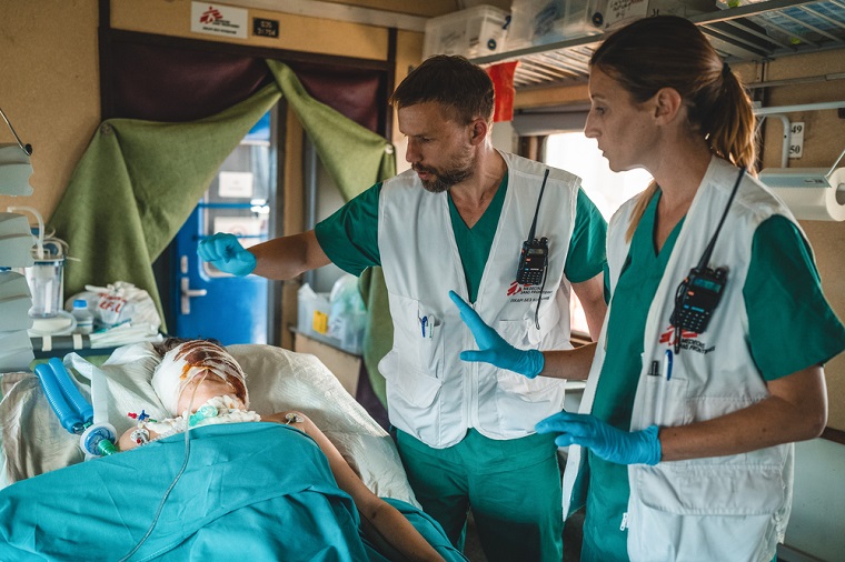 MSF医療列車の集中治療室で重傷を負った患者の容体を安定させる医師と看護師。患者はその後リビウの病院で必要な専門治療を受ける　© Andrii Ovod