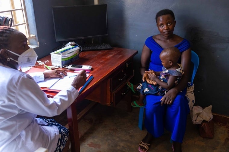 TACTiCプロジェクトを実施するウガンダの施設に訪れた親子　© Stuart Tibaweswa