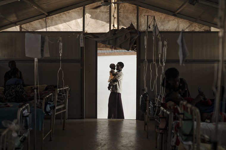 南スーダン、ベンティウにあるMSFの病院で妹を抱く女性。女性は肺炎と高熱を患っていたが順調に回復している ©Sean Sutton