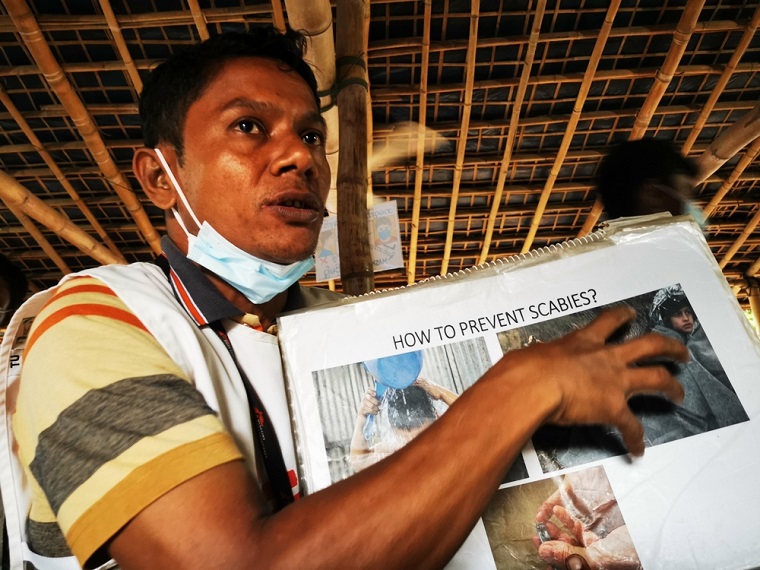 疥癬の感染方法や治療の仕方を写真や絵を使って説明する=2023年6月1日 © MSF/Malvoisin