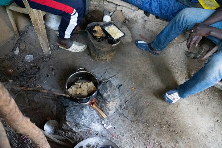 ホットスポットで配給された食事を温める男性たち © Evgenia Chorou