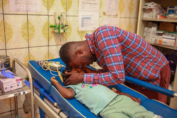 カメルーン北西州の病院で足の治療を受ける少女とその父親=2020年11月 © MSF/Scott Hamilton