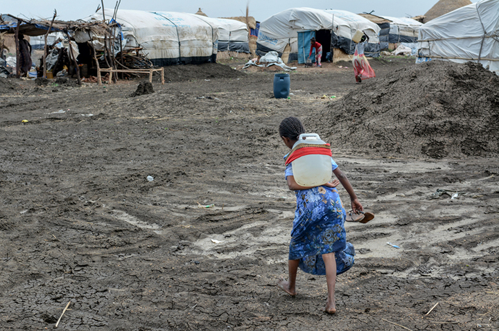 アル・タニデバ・キャンプで水の入った容器をテントまで運ぶ少女　© MSF/Dalila Mahdawi 