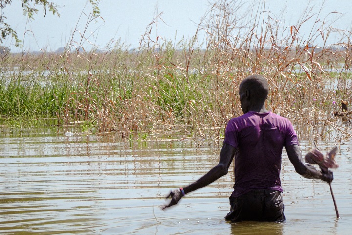 ユニティー州の州都ベンティウで洪水の中を歩く男性=2021年11月18日 © Njiri Karago/ MSF