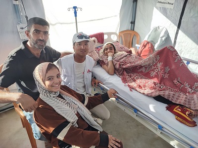 仮設病院を開院後、最初に入院した女性とその家族と © MSF
