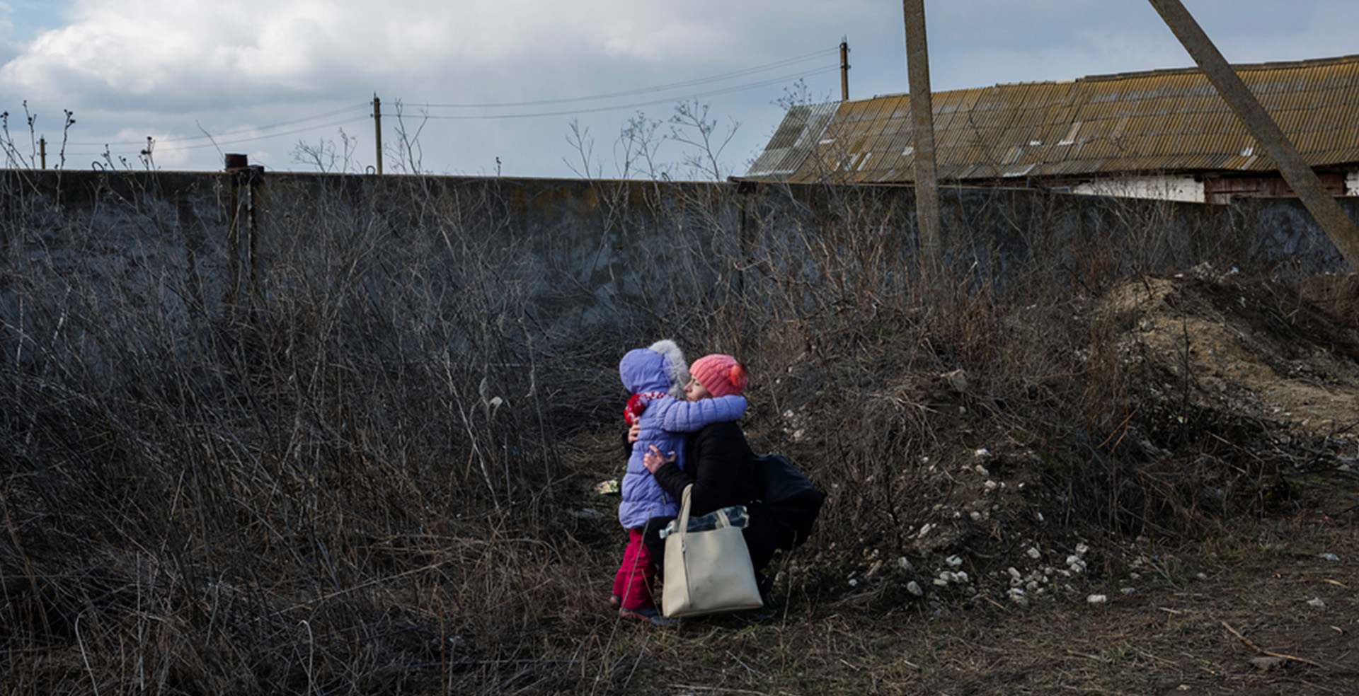 モルドバのパランカで、バスの出発を待つ間に母親が娘を抱きしめる。2月に戦争状態となったウクライナでは、激しい戦闘により多くの人が家を追われ、国内外での避難を余儀なくされている＝2022年3月　Ⓒ Maxime Fossat