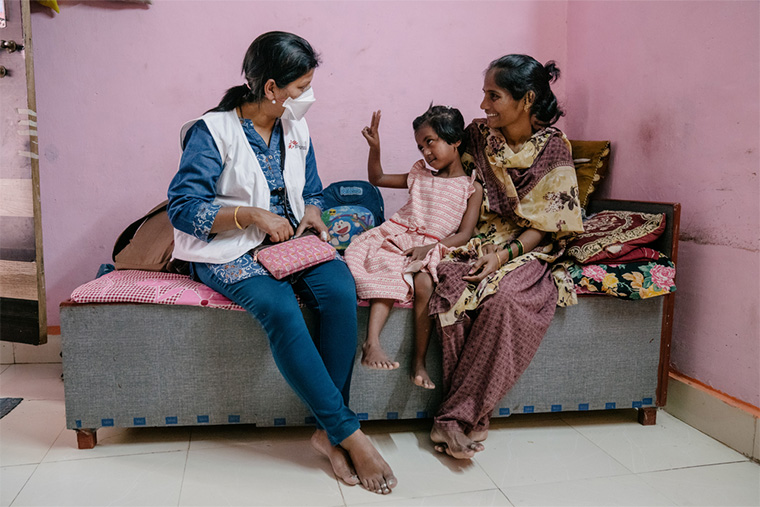 インドのムンバイで、MSFの看護師が訪問診療を行う。看護師と話す薬剤耐性結核患者のヴァイシュナヴィさんと、それを見守る母ヴィシャカさん＝2022年2月　Ⓒ Prem Hessenkamp