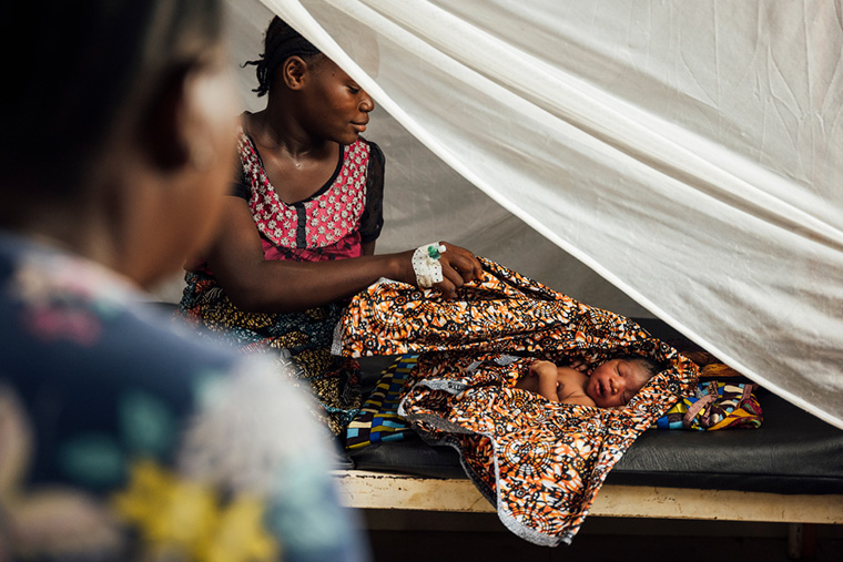 シエラレオネのトンコリリにあるMSFが支援する地域保健センターで、出産した新生児を見守る母親のアミナータさん＝2022年3月　Ⓒ Oliver Barth/MSF