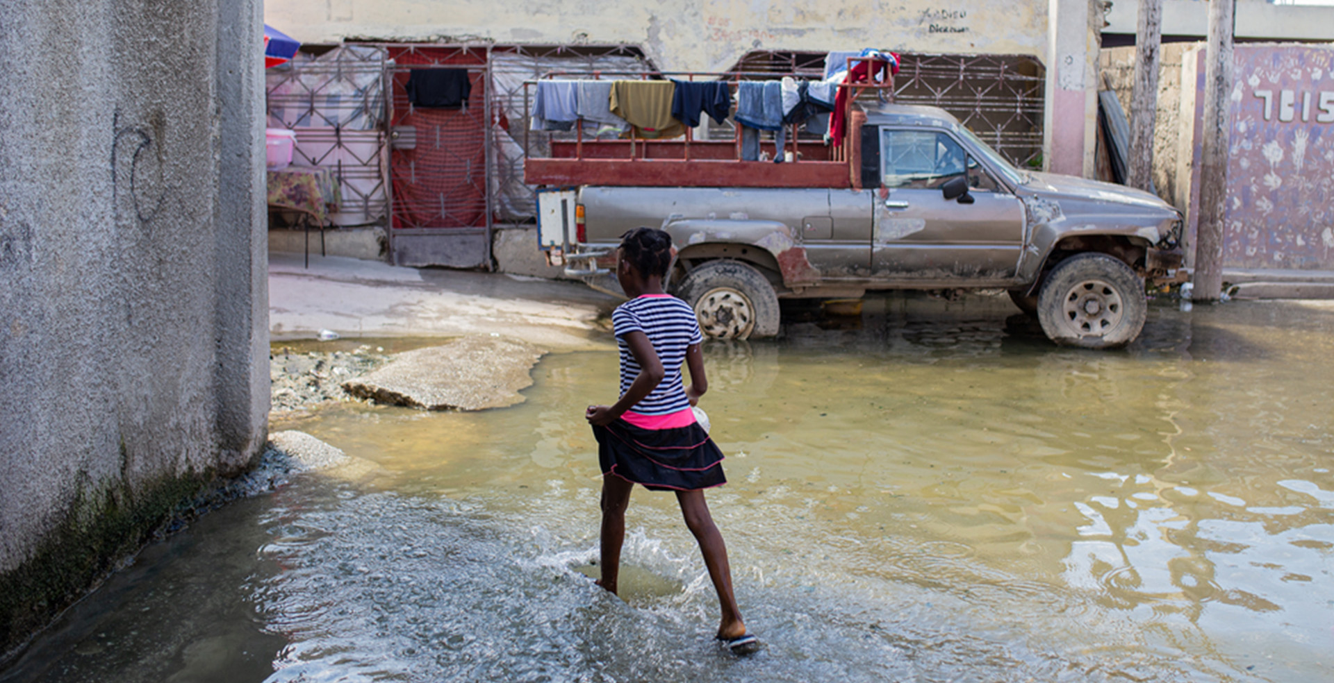 ハイチの首都、ポルトープランスで浸水した道路を渡る子ども。下水の処理が不十分で、清潔な水が手に入らない環境では、コレラが急速に蔓延する＝2022年10月　Ⓒ MSF/Alexandre Marcou