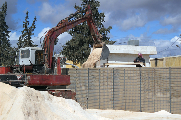 病院の周囲に防護壁を建設。ショベルカー調達から工事作業まで地元の人が協力　© MSF